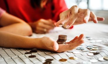 hands on a table holding coins