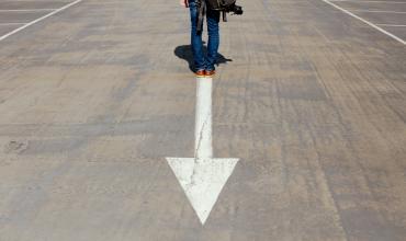 A person standing on an arrow in the road