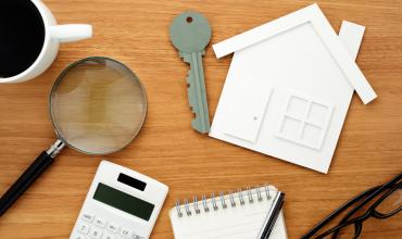 house, calculator and keys on a table