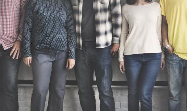 A group of people standing next to a wall