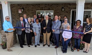 ribbon cutting in front of shepard greene