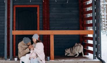 A couple holding hands on their front porch in the winter