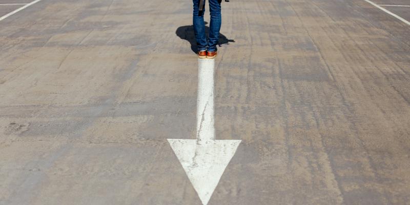 a person standing on a street with an arrow in it