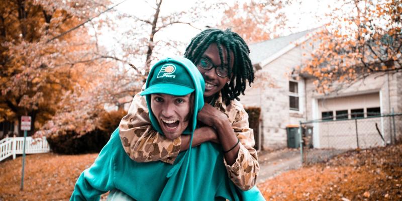 Two people piggybacking on a street