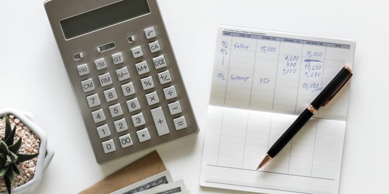 a calculator and checkbook on a table