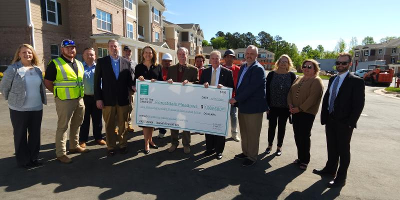 Group of people holding up a large check