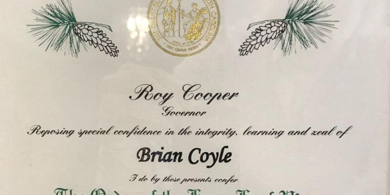 NC Housing Partnership Chair Brian Coyle Awarded Order of the Long Leaf Pine A photo of the award