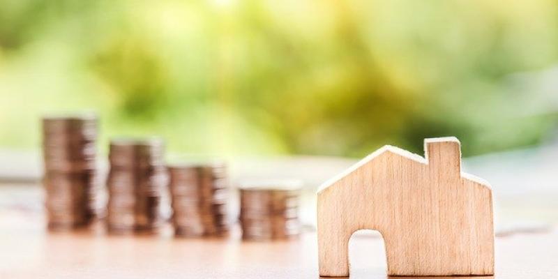 Little wooden house with coins in background