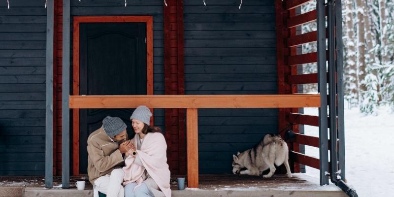 A couple holding hands on their front porch in the winter