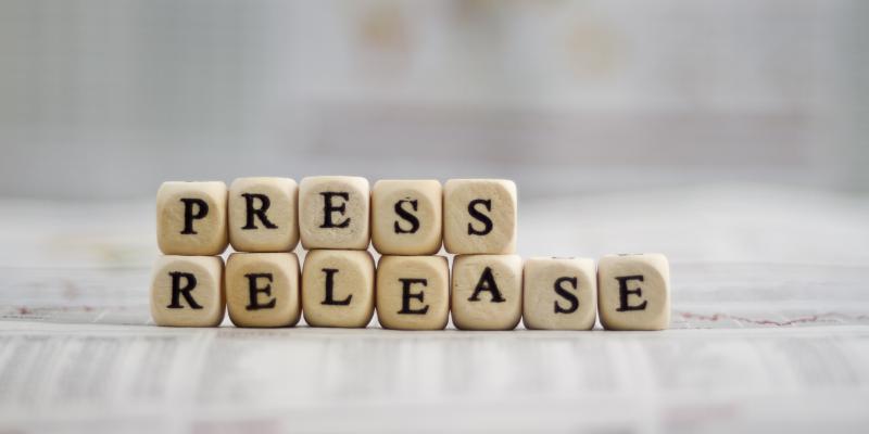 Lettered blocks stacked to say press release on a white table